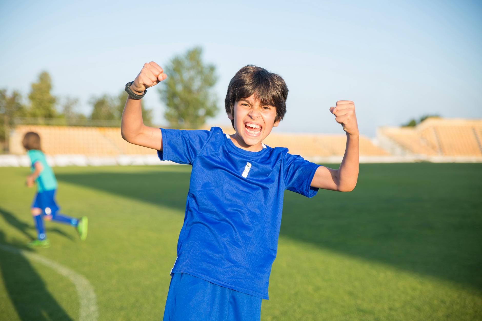 young soccer player celebrating goal with team